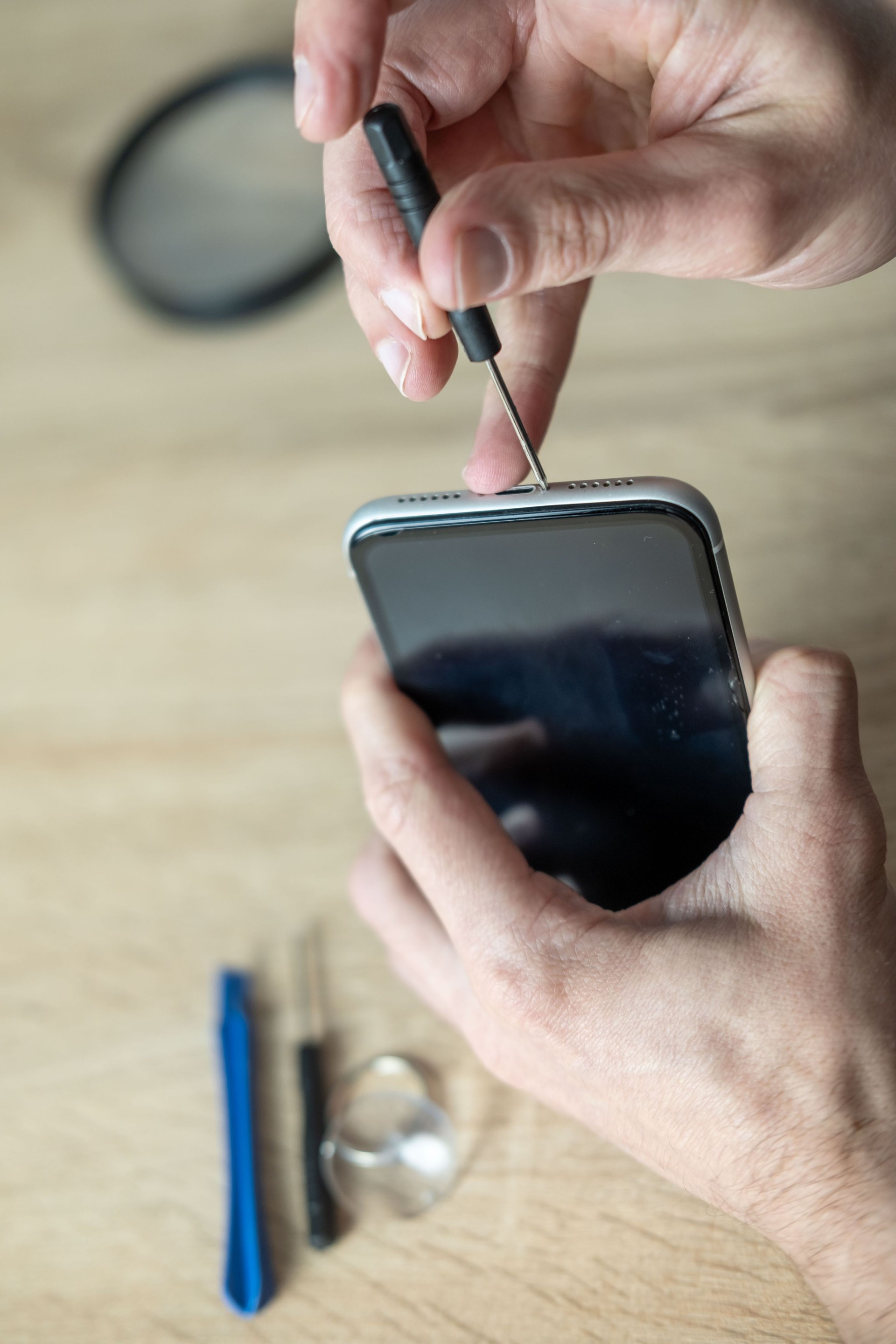 Hands repairing smartphone hardware with small tools. Mobile phone maintenance, repair service and technology concept, technical support, service center, display replacement